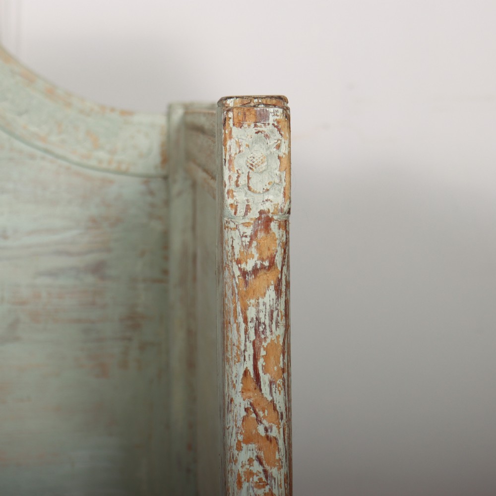 A pale green painted Swedish wooden bench featuring a shaped crest rail, panelled sides, and a natural pine seat. View VI