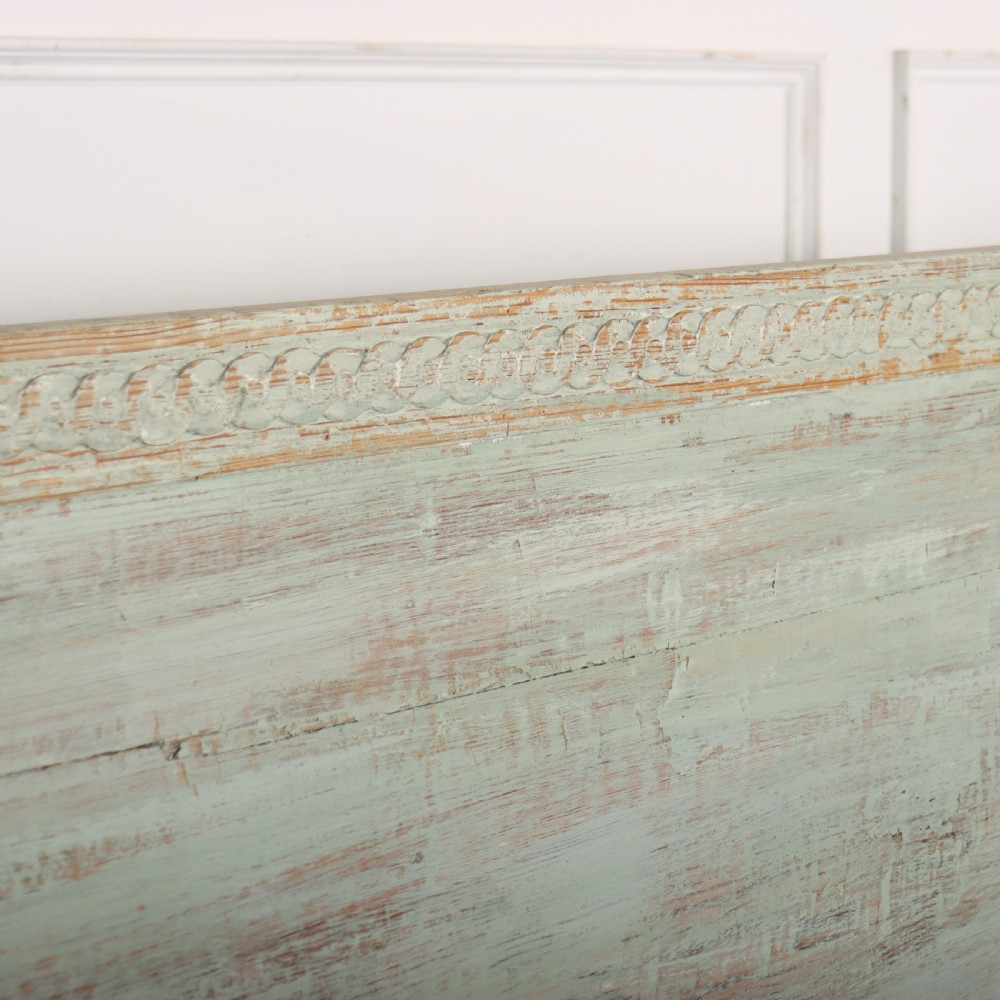 A pale green painted Swedish wooden bench featuring a shaped crest rail, panelled sides, and a natural pine seat. View VII