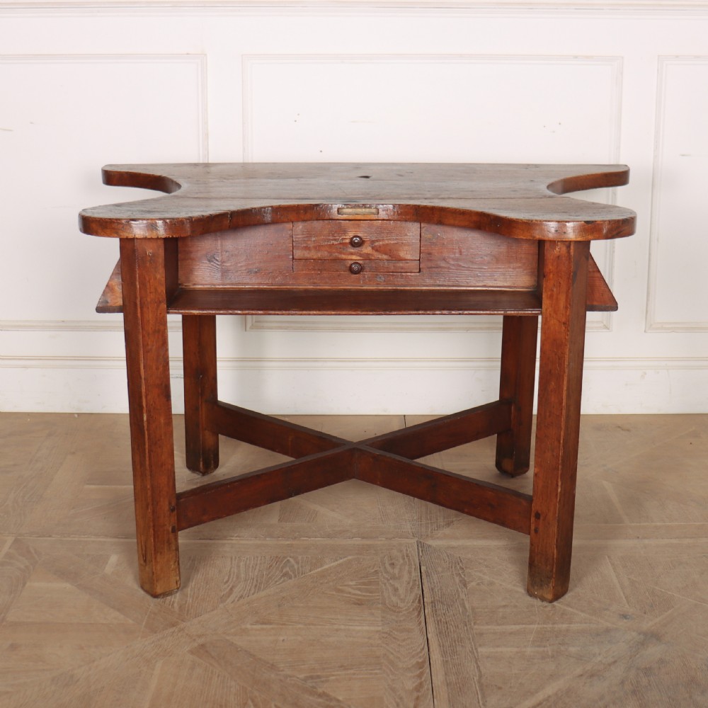 A nineteenth-century French wooden watchmakers table featuring a contoured ergonomic front cut-out, small drawers, and cross-braced square legs. View III