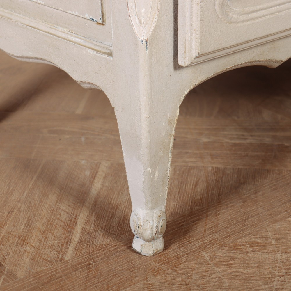 A pair of light cream painted French commodes featuring three drawers each, detailed with brass handles, carved apron shells, and cabriole legs. View XI