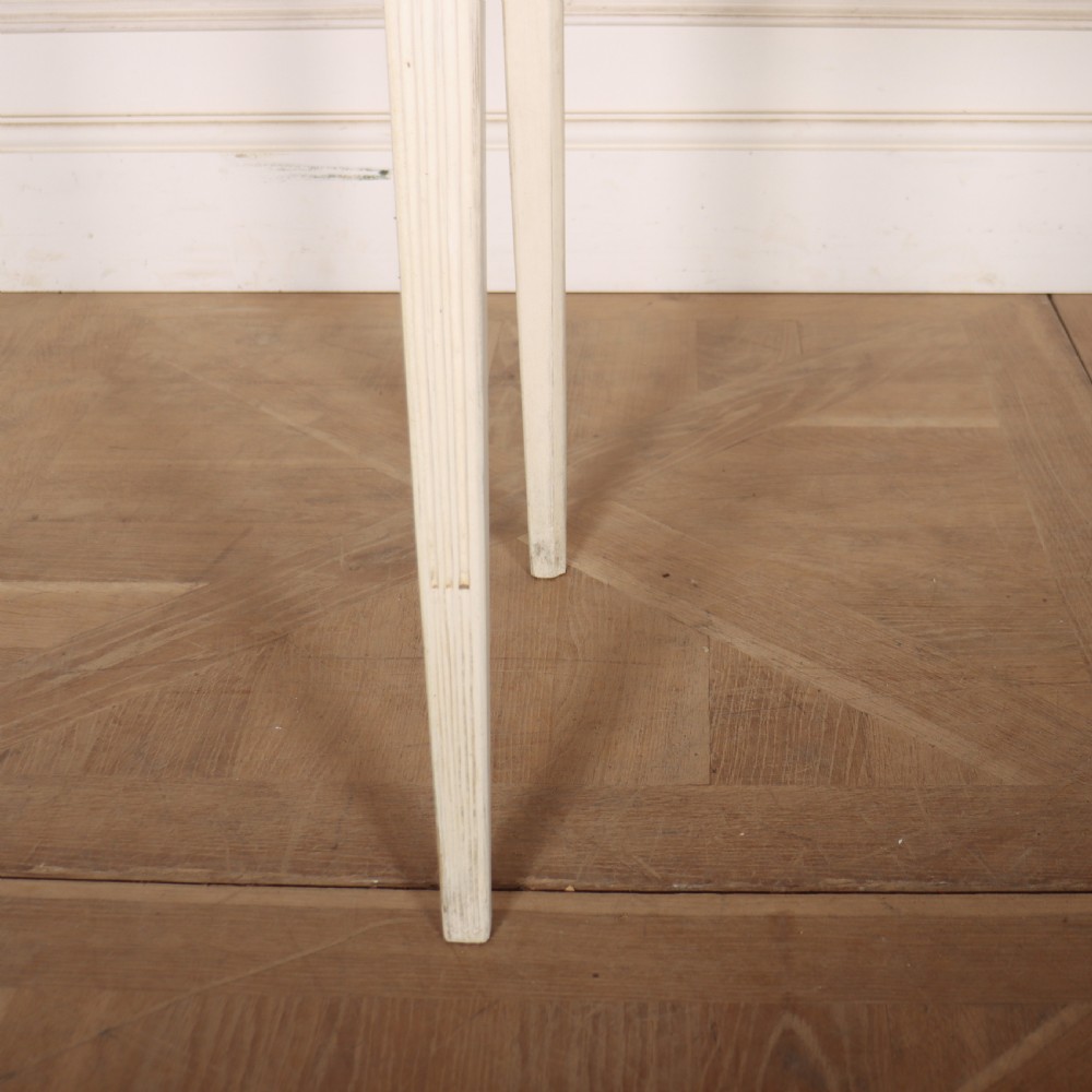 An off-white painted French side table with a serpentine front, fluted double drawer panels, and tapered square legs. View III