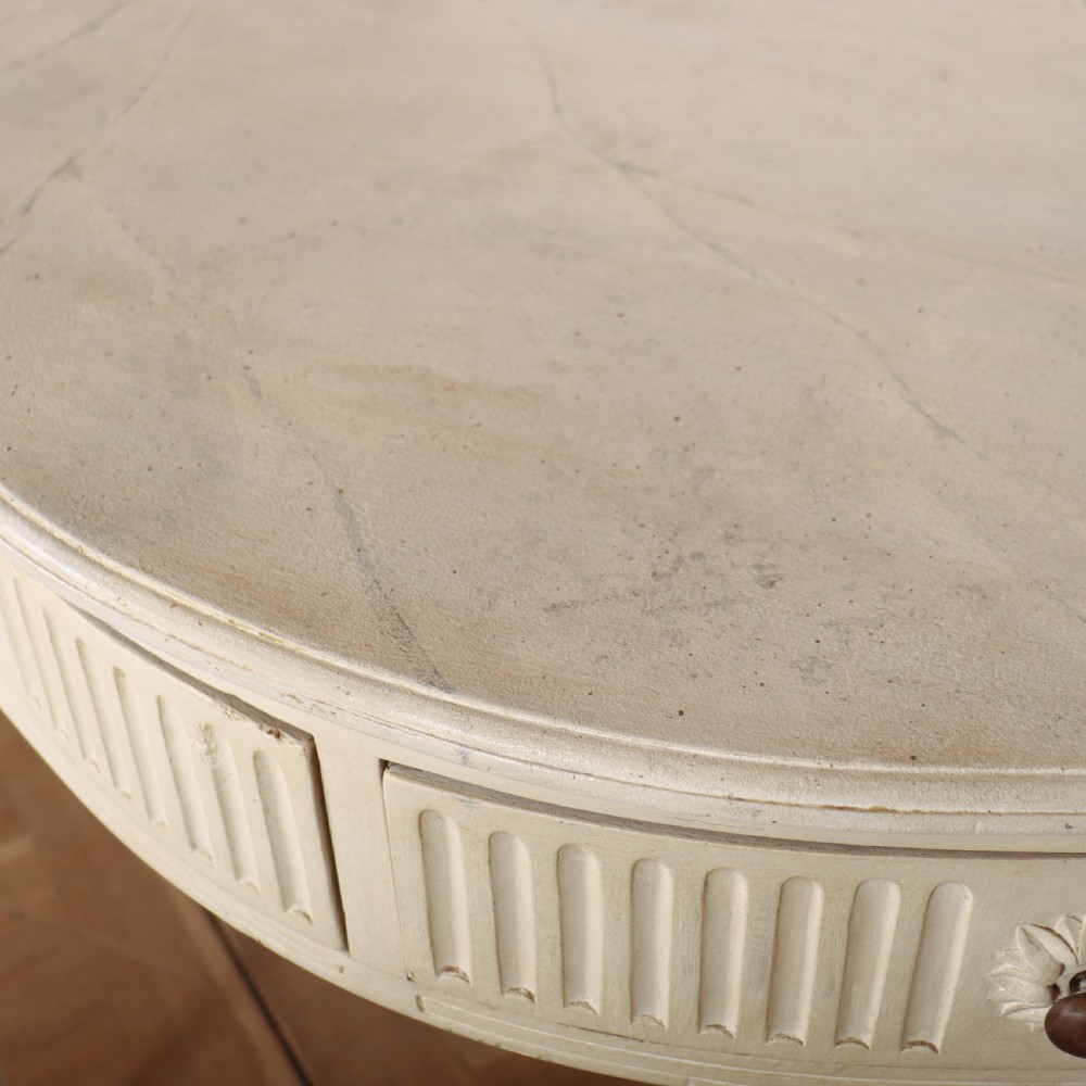 An off-white painted French side table with a serpentine front, fluted double drawer panels, and tapered square legs. View X