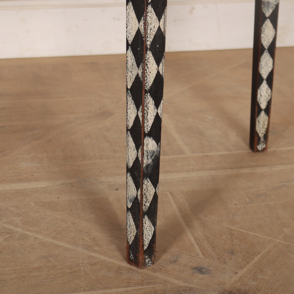 A pair of semi-circular painted timber console tables decorated with a black and white diamond harlequin pattern along the aprons and tapered legs. View IV