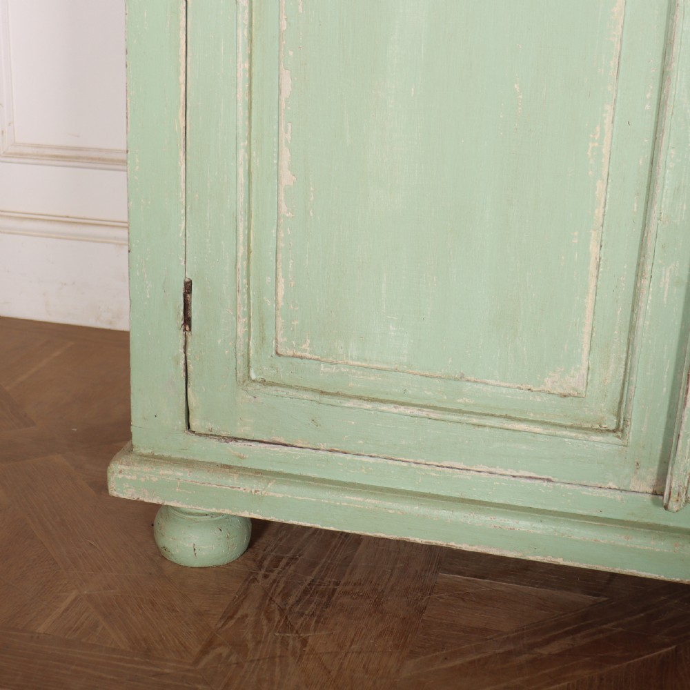 A large four-door wooden buffet painted in a soft pale green finish with simple panelled doors and turned feet. View IV