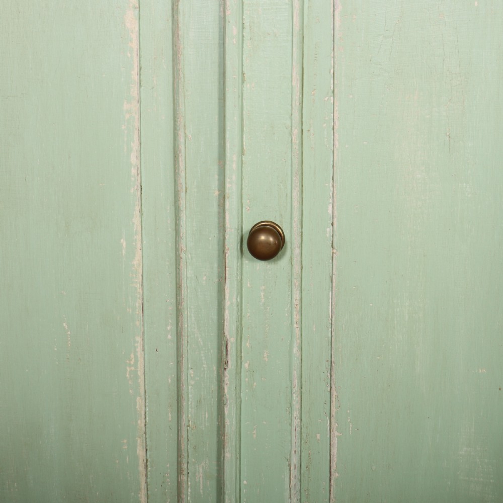 A large four-door wooden buffet painted in a soft pale green finish with simple panelled doors and turned feet. View VI