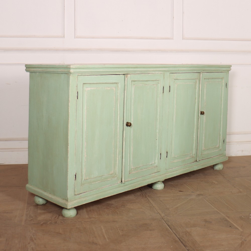 A large four-door wooden buffet painted in a soft pale green finish with simple panelled doors and turned feet. View IX