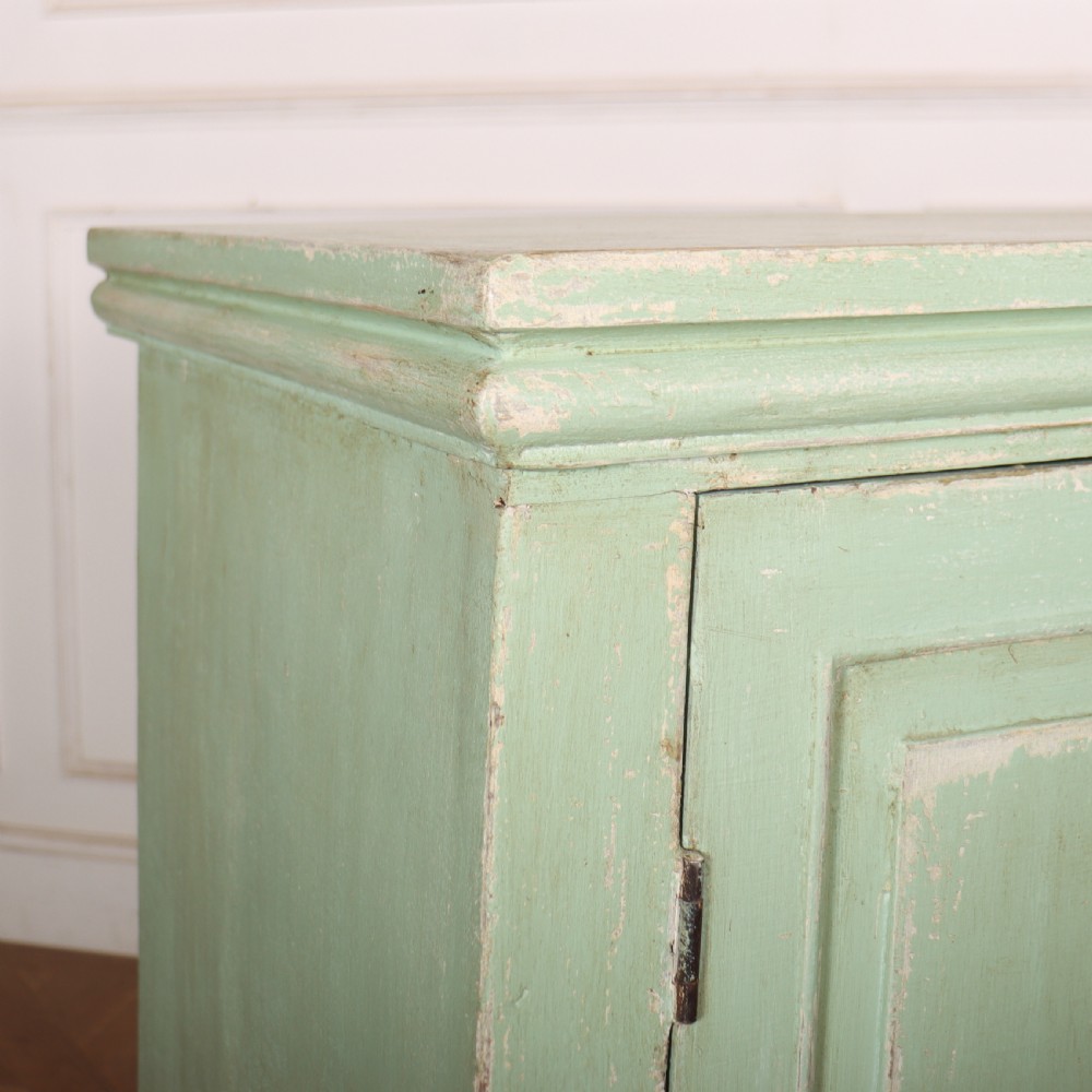 A large four-door wooden buffet painted in a soft pale green finish with simple panelled doors and turned feet. View X