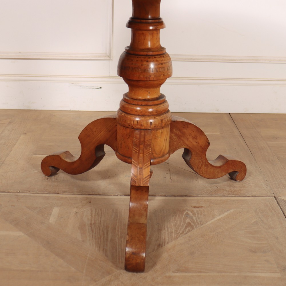 A circular 19th-century Swedish birch centre table featuring a turned central pedestal column resting on curved feet. View II