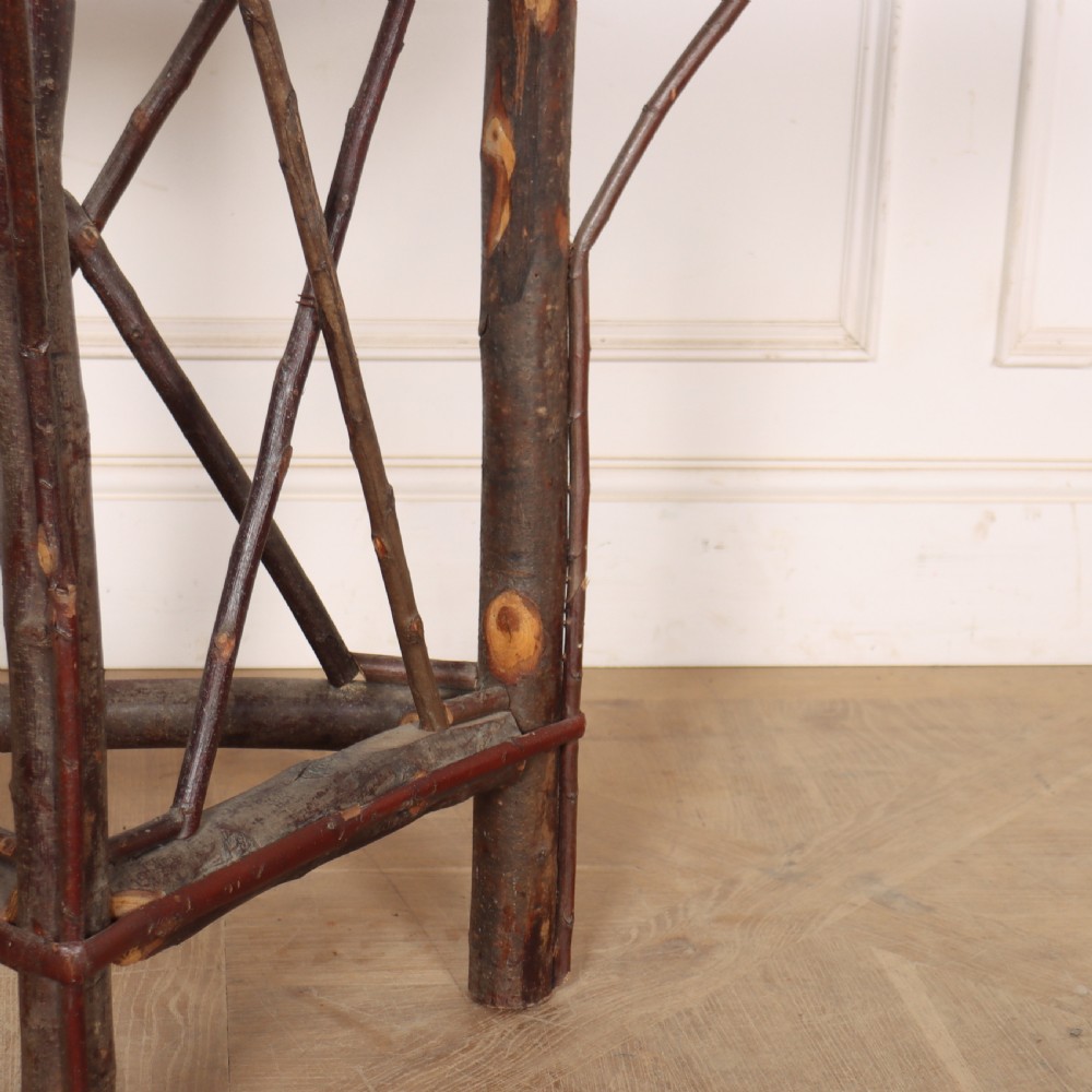 A demilune console table crafted from unpeeled rustic tree branches with a patterned teal painted top. View II