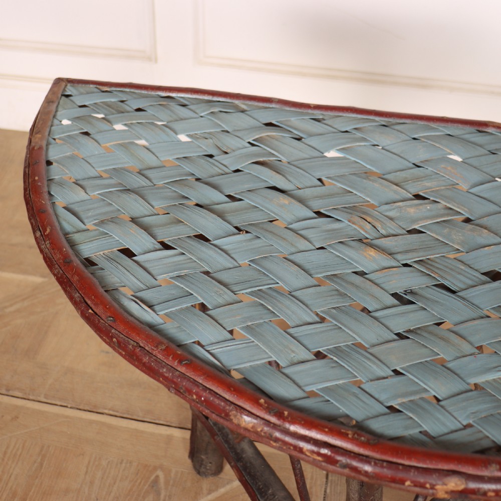 A demilune console table crafted from unpeeled rustic tree branches with a patterned teal painted top. View IV