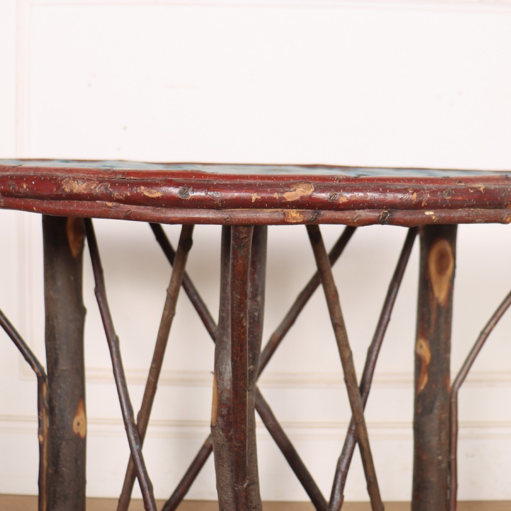 A demilune console table crafted from unpeeled rustic tree branches with a patterned teal painted top. View V