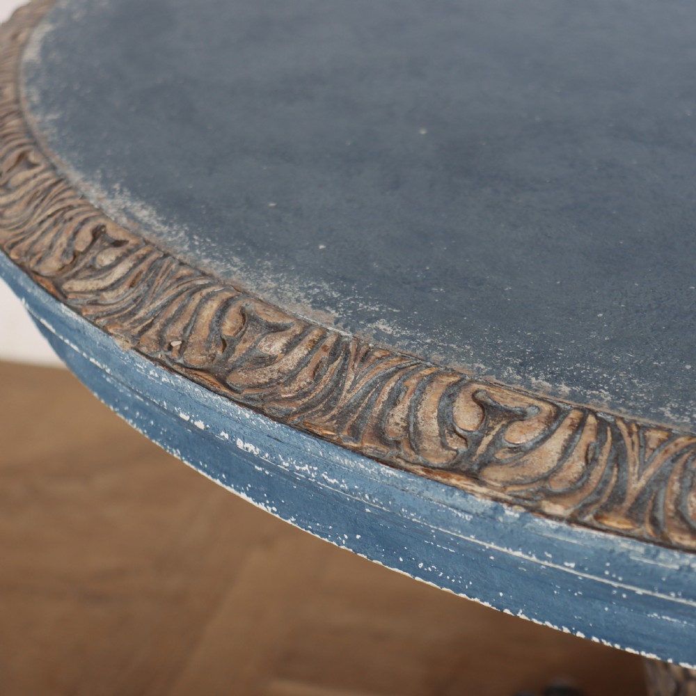 A circular 1920s German centre table featuring a distressed slate blue painted finish, gilt carved acanthus leaf pedestal, and scroll feet. View VIII