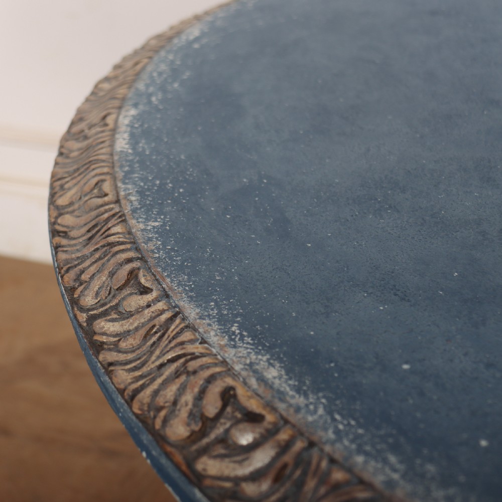 A circular 1920s German centre table featuring a distressed slate blue painted finish, gilt carved acanthus leaf pedestal, and scroll feet. View X