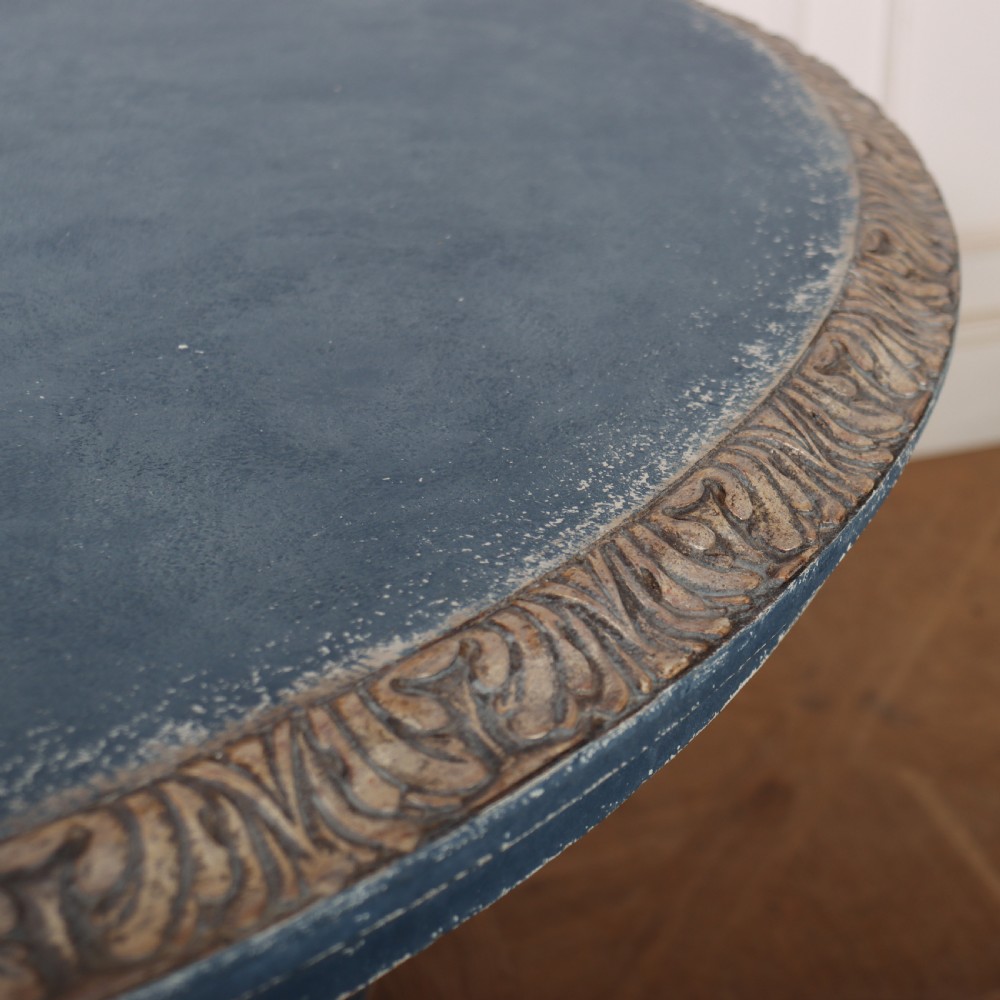 A circular 1920s German centre table featuring a distressed slate blue painted finish, gilt carved acanthus leaf pedestal, and scroll feet. View XI