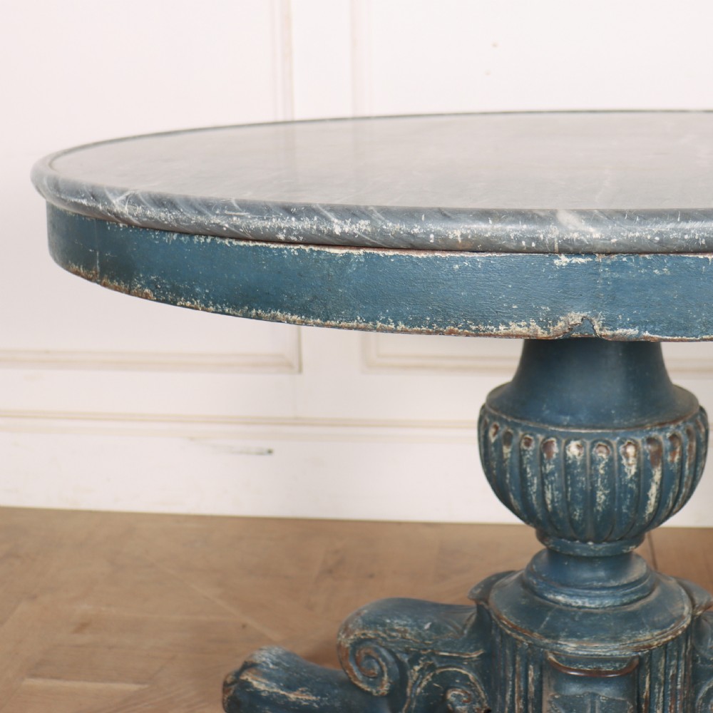 A circular French gueridon table featuring a grey marble top and a distressed blue painted pedestal base resting on carved scroll feet. View IV
