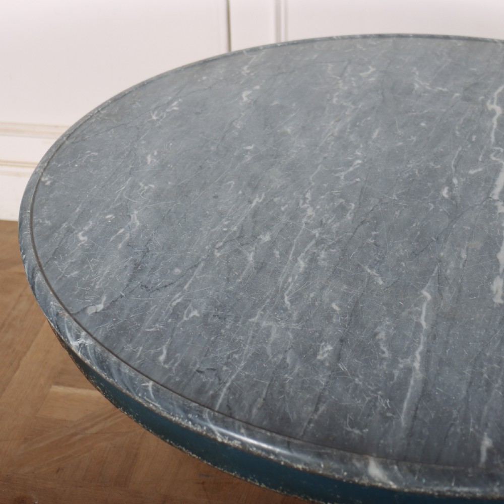 A circular French gueridon table featuring a grey marble top and a distressed blue painted pedestal base resting on carved scroll feet. View VI