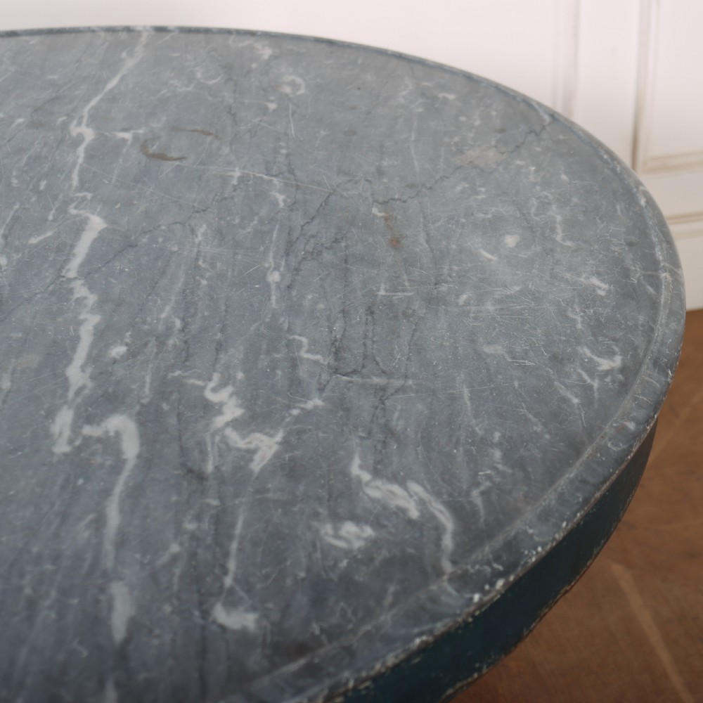 A circular French gueridon table featuring a grey marble top and a distressed blue painted pedestal base resting on carved scroll feet. View VII