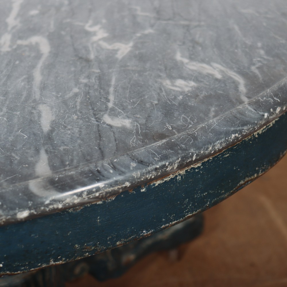 A circular French gueridon table featuring a grey marble top and a distressed blue painted pedestal base resting on carved scroll feet. View VIII