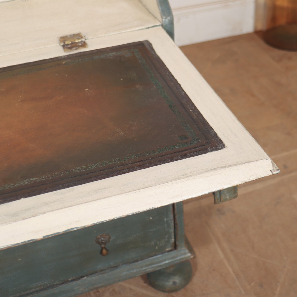 An 18th-century English slant-front bureau with a distressed grey-green painted finish, brass pull handles, and turned feet. View V