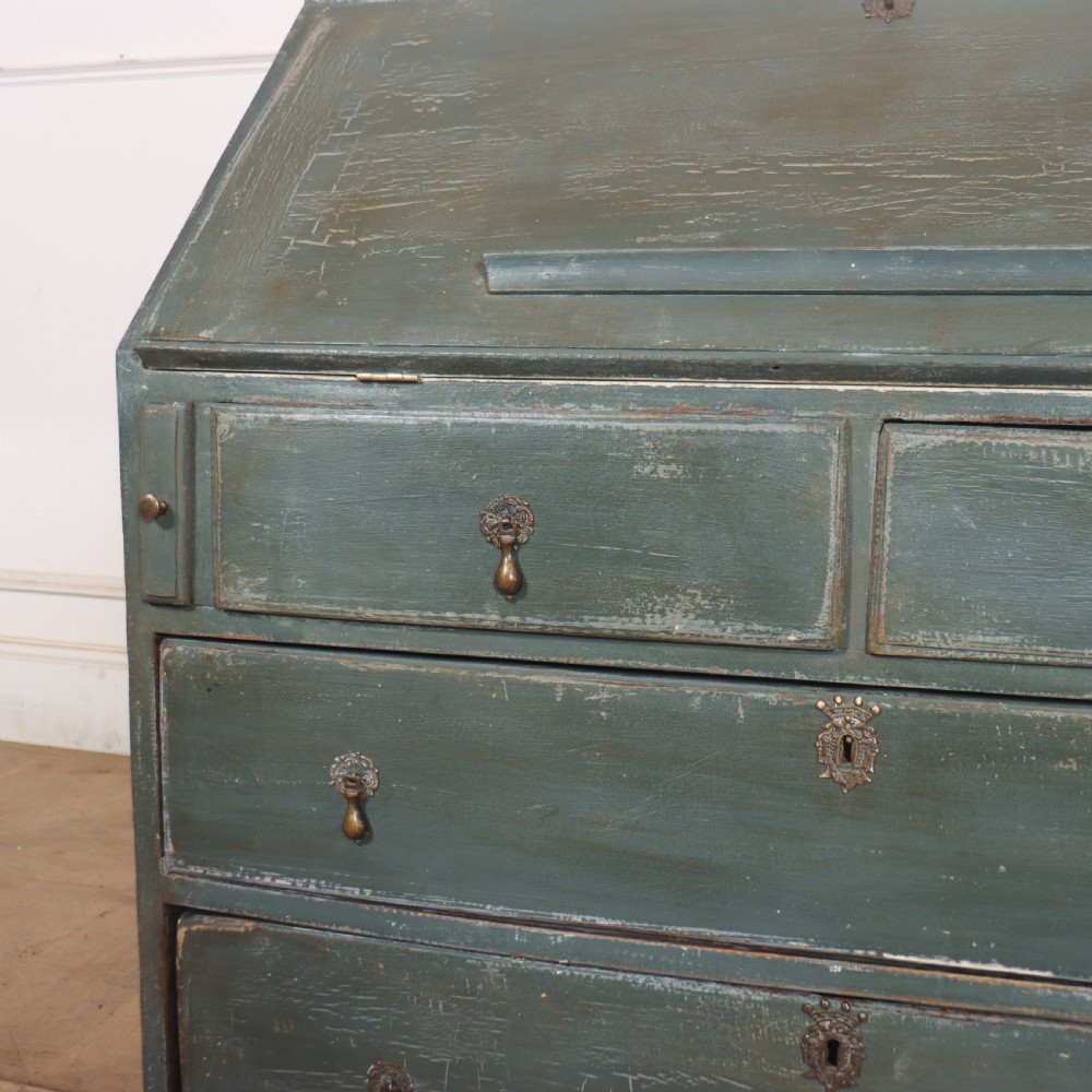 An 18th-century English slant-front bureau with a distressed grey-green painted finish, brass pull handles, and turned feet. View X