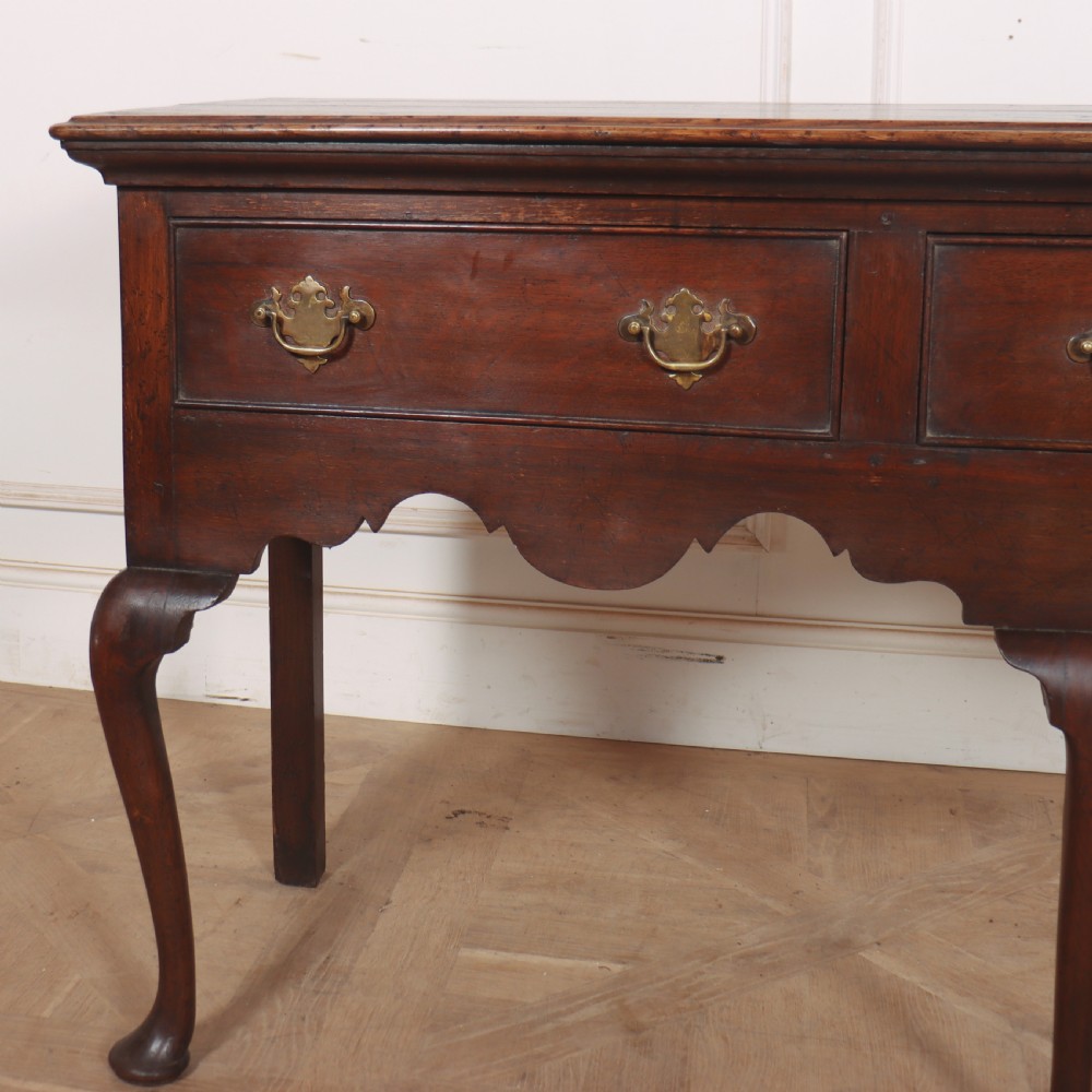 An 18th-century style dark oak dresser base featuring three frieze drawers, brass handles, a shaped apron, and elegant cabriole legs. View II