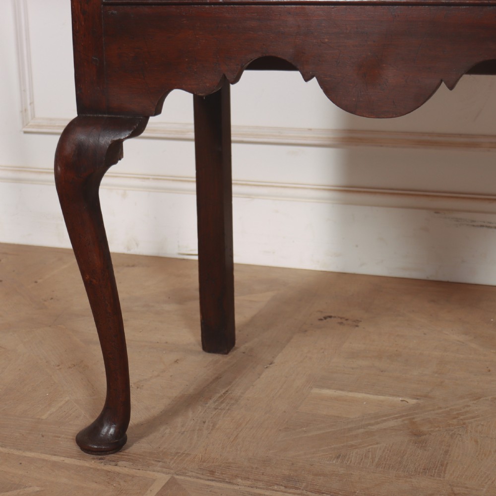 An 18th-century style dark oak dresser base featuring three frieze drawers, brass handles, a shaped apron, and elegant cabriole legs. View VI