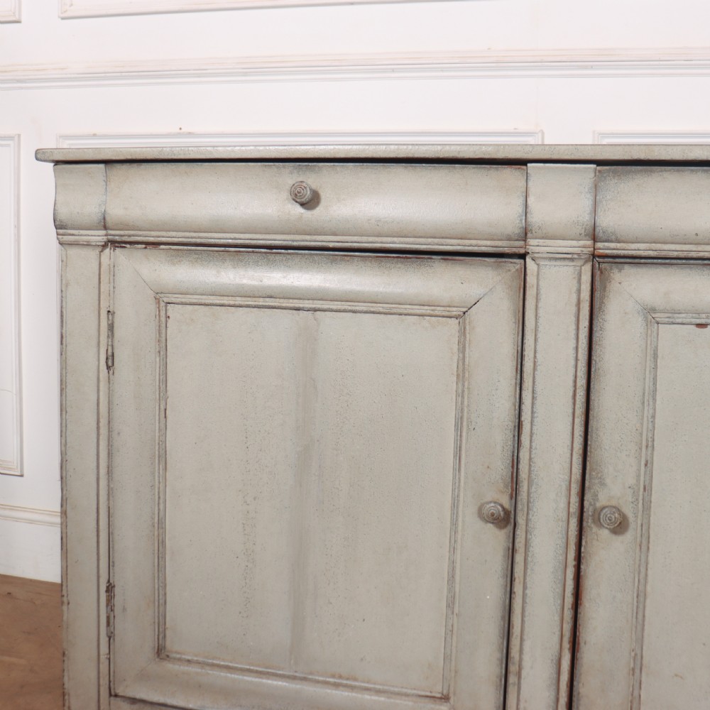 An antique French painted narrow enfilade in a distressed grey finish with three drawers over three panelled doors. View II