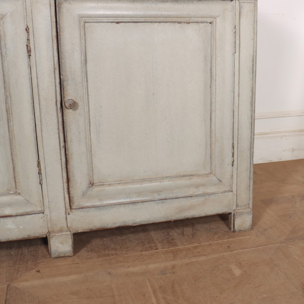 An antique French painted narrow enfilade in a distressed grey finish with three drawers over three panelled doors. View V