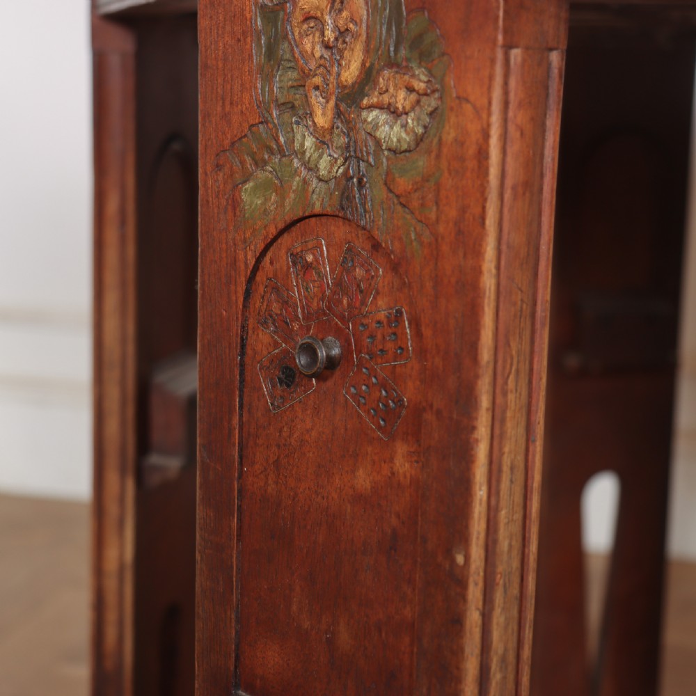 An antique hexagonal Arts and Crafts walnut card table featuring a green baize top, pierced leg details, and integrated drawers. View IV