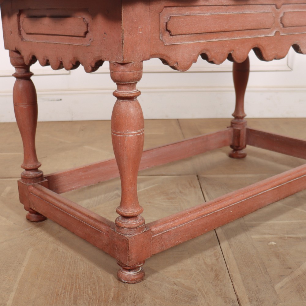 An 18th-century Dutch Baroque side table with a terracotta red painted finish, scalloped top, shaped apron, turned baluster legs, and a box stretcher. View II