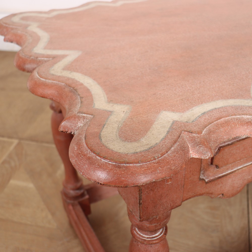 An 18th-century Dutch Baroque side table with a terracotta red painted finish, scalloped top, shaped apron, turned baluster legs, and a box stretcher. View V