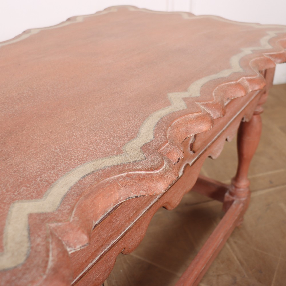 An 18th-century Dutch Baroque side table with a terracotta red painted finish, scalloped top, shaped apron, turned baluster legs, and a box stretcher. View IX