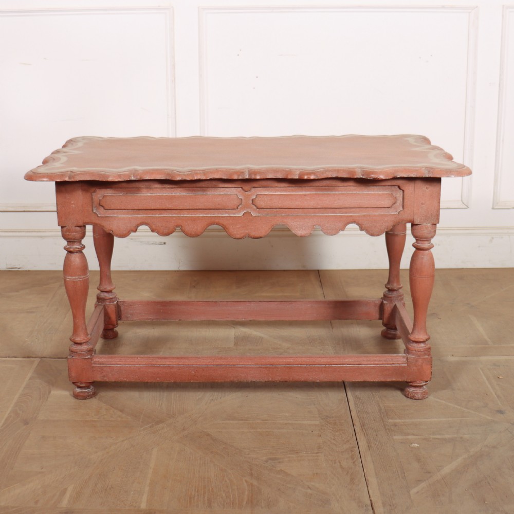An 18th-century Dutch Baroque side table with a terracotta red painted finish, scalloped top, shaped apron, turned baluster legs, and a box stretcher. View X