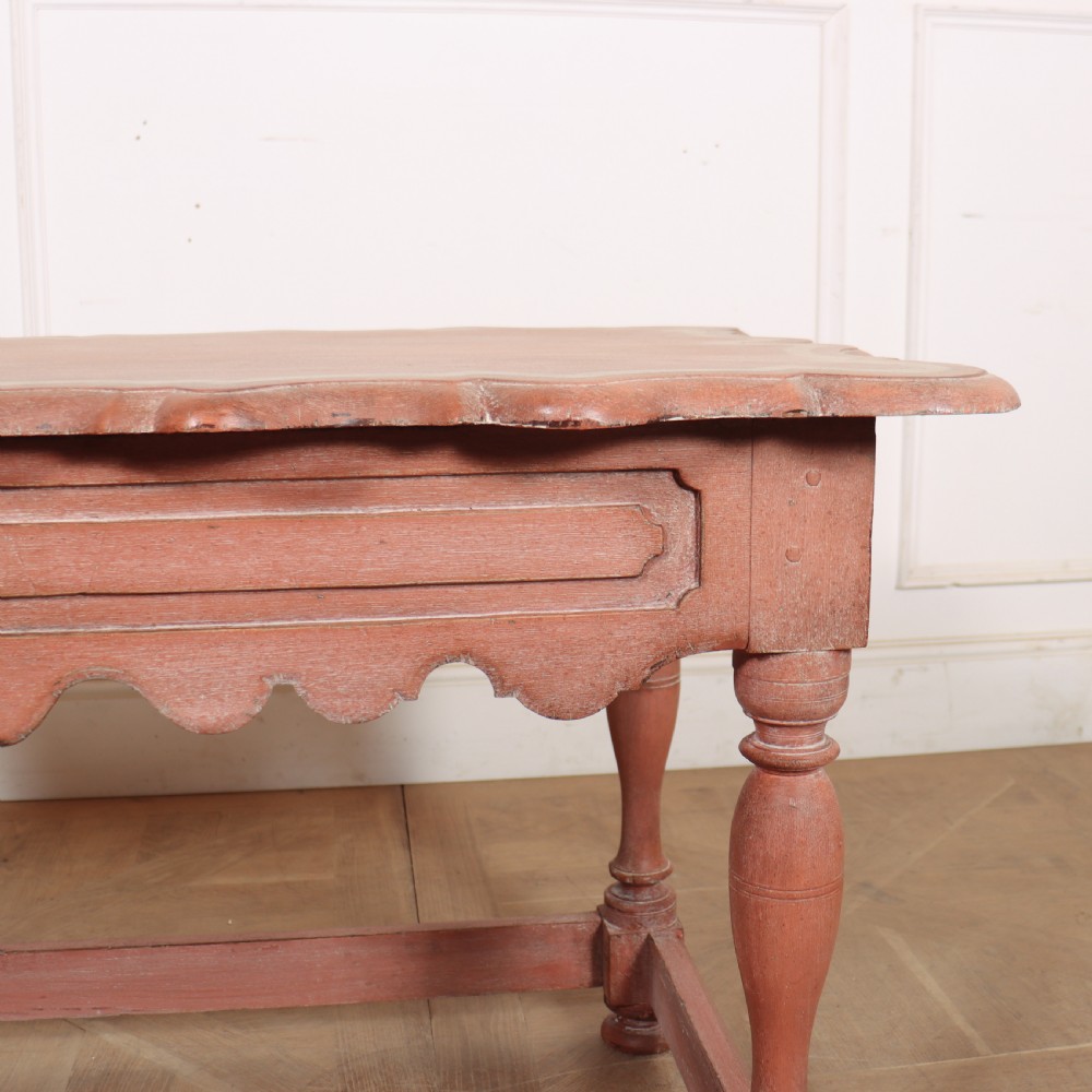 An 18th-century Dutch Baroque side table with a terracotta red painted finish, scalloped top, shaped apron, turned baluster legs, and a box stretcher. View XI