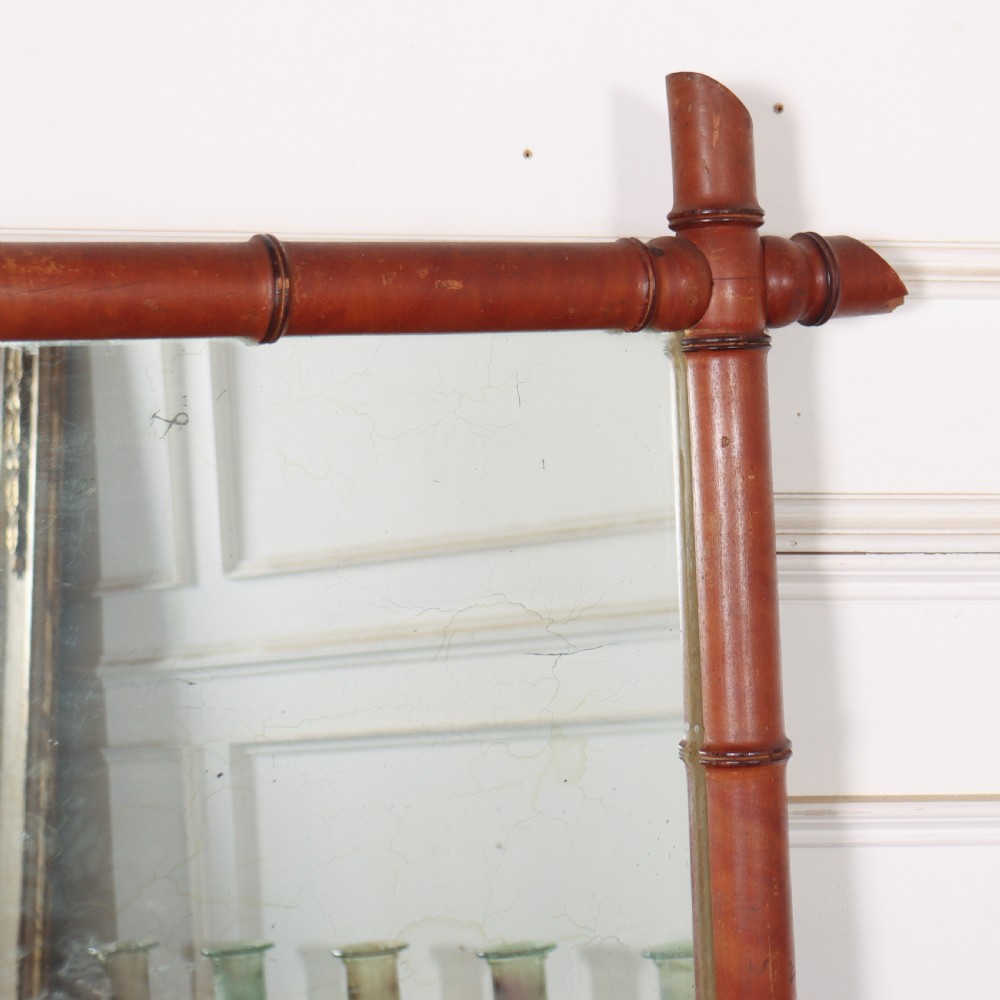 A large rectangular mirror framed in warm brown turned wood designed to mimic bamboo with extending corner joints. View III
