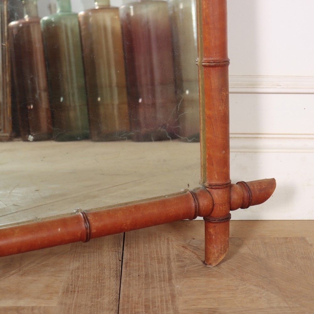 A large rectangular mirror framed in warm brown turned wood designed to mimic bamboo with extending corner joints. View IV