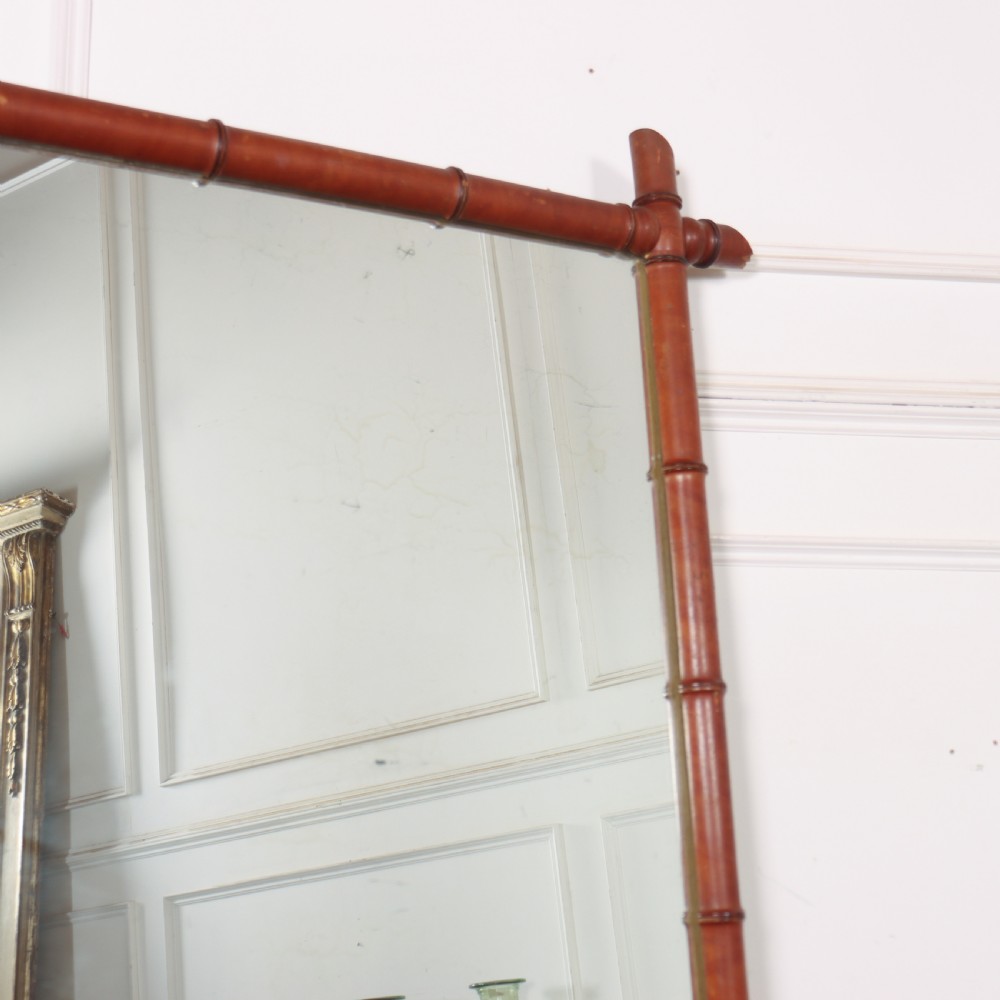 A large rectangular mirror framed in warm brown turned wood designed to mimic bamboo with extending corner joints. View VII