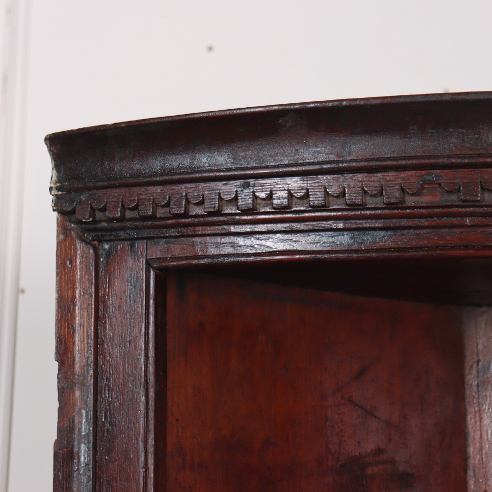 An 18th-century English dark wood hanging corner cupboard with three open curved shelves and moulded cornice. View II