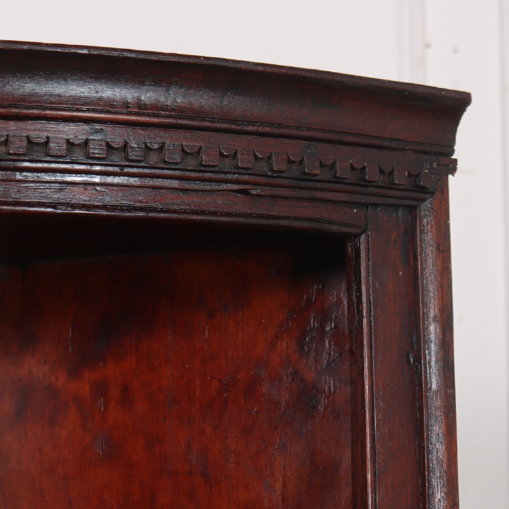 An 18th-century English dark wood hanging corner cupboard with three open curved shelves and moulded cornice. View III