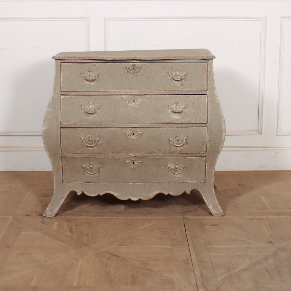 A 19th-century Dutch bombe commode featuring a distressed grey painted finish, four drawers, and decorative brass hardware.
