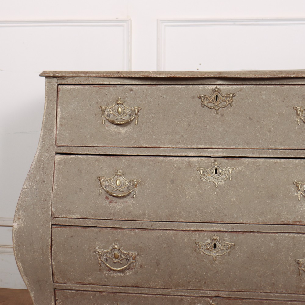 A 19th-century Dutch bombe commode featuring a distressed grey painted finish, four drawers, and decorative brass hardware. View II