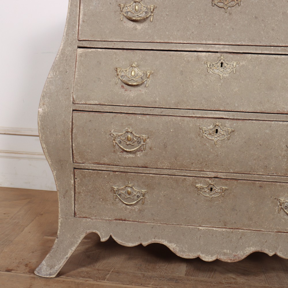 A 19th-century Dutch bombe commode featuring a distressed grey painted finish, four drawers, and decorative brass hardware. View IV