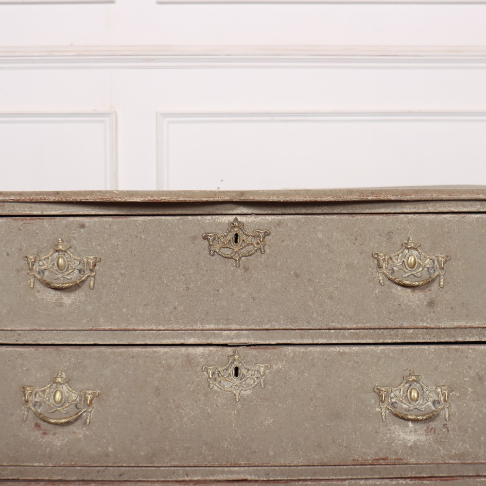 A 19th-century Dutch bombe commode featuring a distressed grey painted finish, four drawers, and decorative brass hardware. View VI