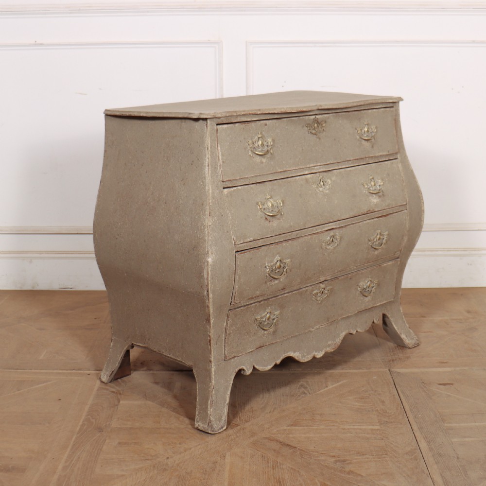 A 19th-century Dutch bombe commode featuring a distressed grey painted finish, four drawers, and decorative brass hardware. View VII
