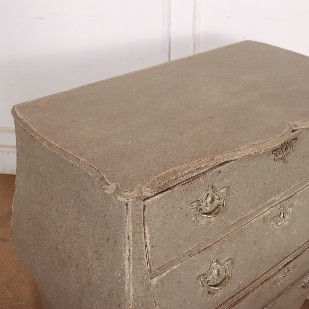 A 19th-century Dutch bombe commode featuring a distressed grey painted finish, four drawers, and decorative brass hardware. View IX