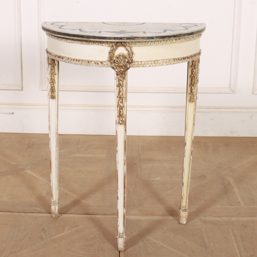 A French Louis XVI style cream painted and gilded demi-lune console table with tapered legs.