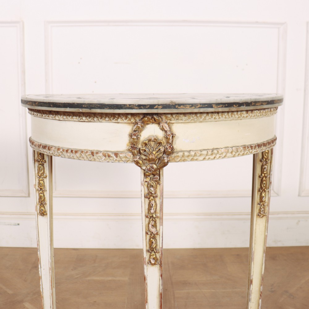 A French Louis XVI style cream painted and gilded demi-lune console table with tapered legs. View II