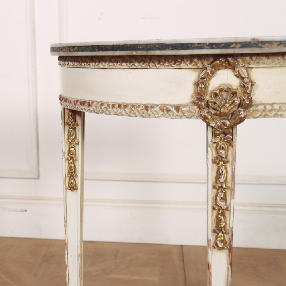 A French Louis XVI style cream painted and gilded demi-lune console table with tapered legs. View III