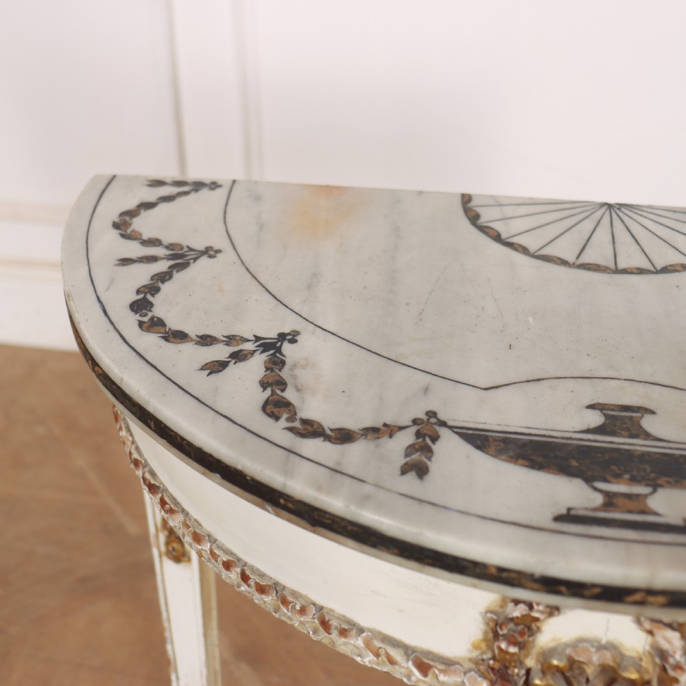 A French Louis XVI style cream painted and gilded demi-lune console table with tapered legs. View VI
