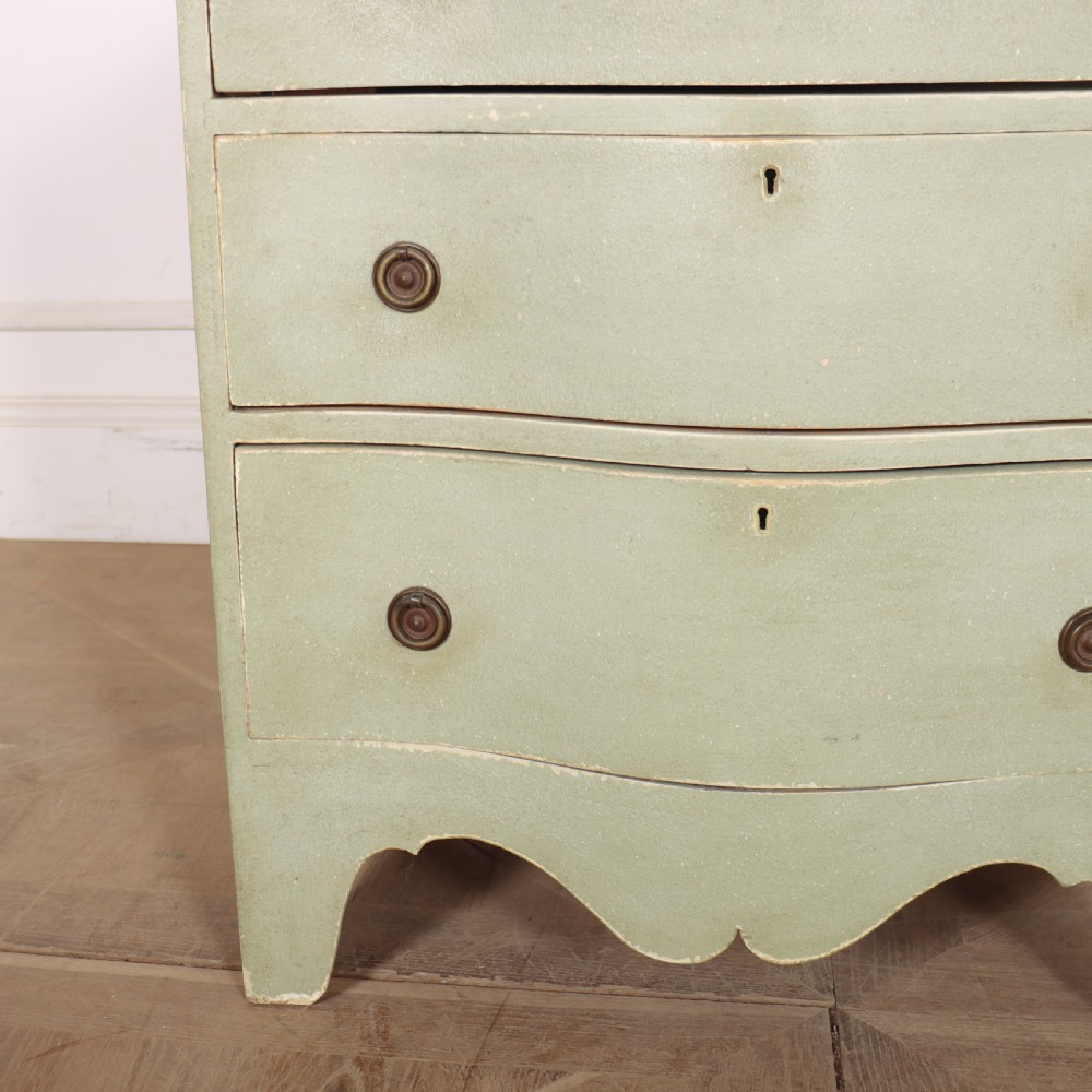 A Swedish serpentine painted commode featuring three drawers with brass pulls and a shaped apron in a muted green finish. View V